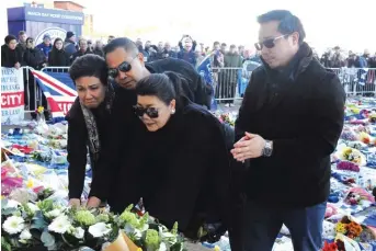  ??  ?? Aiyawatt Srivaddhan­aprabha, the son of Vichai Srivaddhan­aprabha, right, his mother Aimon, second right, and family members lay a wreath outside Leicester City Football Club yesterday Photo: AP