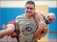  ?? PHOTOS BY ?? Left, Steve DeRosa carries teammate Jeff Rochester in a drill Feb. 5 during a practice of the New London County Rugby Football Club at Lyme-Old Lyme High School. SARAH GORDON THE DAY