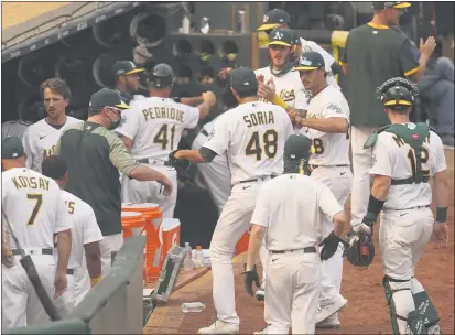  ?? PHOTOS BY ERIC RISBERG — THE ASSOCIATED PRESS ?? A’s relief pitcher Joakim Soria (48) is greeted by teammates after retiring the White Sox in the eighth inning of Game 3 of an American League wild-card series Thursday in Oakland.