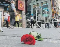  ?? AP PHOTO ?? A single rose is left on the sidewalk to honour a victim in New York’s Times Square, Friday.