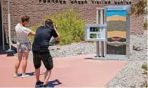  ?? ?? Tourists stop to take photos of a thermostat reading 119 degrees Fahrenheit on Tuesday at the Furnace Creek visitor center.
