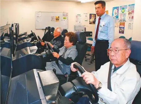  ?? Getty Image ?? Seniors take a simulated driving test at a driving school in Kofu, Yamanashi. Drivers over 75 are now required to take a cognitive test when renewing their licences.