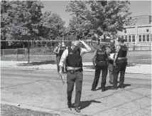  ?? ARMANDO L. SANCHEZ/CHICAGO TRIBUNE ?? Police work the scene near a school playground where a 14-year-old boy was fatally shot in the 1100 block of South Karlov Avenue in Chicago on Thursday.