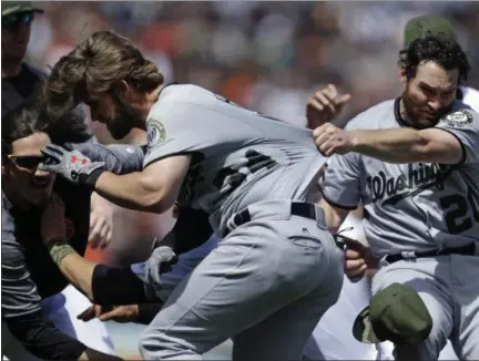  ?? PHOTOS BY BEN MARGOT — ASSOCIATED PRESS ?? Nationals’ Daniel Murphy, right, tries to restrain teammate Bryce Harper after Harper charged Giants’ Hunter Strickland after being hit with a pitch during Monday’s game in San Francisco.