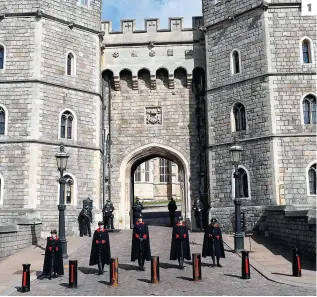  ?? PHOTOS AFP ?? 1. Des gardiens se tenaient devant l’entrée du château de Windsor, hier.
2. Un ouvrage en tricot à l’effigie de la reine Elizabeth II et du prince Philip orne une boîte aux lettres à Windsor. 3. Une personne laissant des fleurs, hier, près des portes du château de Windsor.