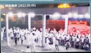  ?? ?? Short-circuiting
Workers at a Shanghai plant that makes Apple MacBooks (inset) are seen rioting at the plant over harsh COVID restrictio­ns, including having to work, eat and sleep on-site and being prevented from seeing other people, including their own families.