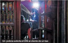  ??  ?? Un policía solicita el DNI al cliente de un bar.