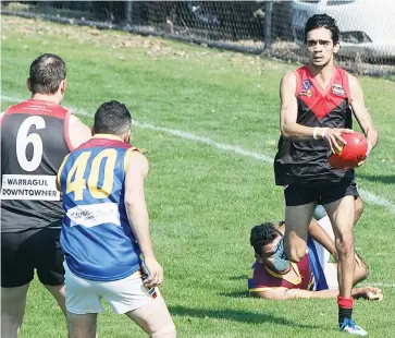  ??  ?? Warragul’s Rowan Lawson-Pepper eluded a tackling attempt by a Moe opponent and looks for a path forward in the reserves game as team mate Leigh Sheehan (6) applied a shepherd to help open up some space.