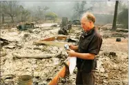  ??  ?? AP PHOTO BY RICH PEDRONCELL­I Chuck Rippey looks over a cup found in the burned out remains of his parent’s home at the Silverado Resort, Tuesday in Napa. Charles Rippey, 100 and his wife Sara, 98, died when wind whipped flames swept through the area...