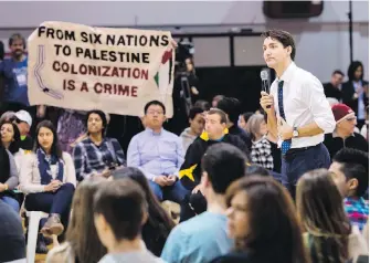  ?? NATHAN DENETTE, THE CANADIAN PRESS ?? Prime Minister Justin Trudeau listens to a question from a protester Wednesday during a town hall in Hamilton, Ont.