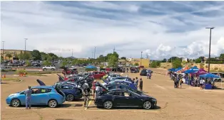  ?? ROBERT NOTT/THE NEW MEXICAN ?? Visitors and prospectiv­e buyers look over nearly three dozen electric cars on display at a car show Saturday at Santa Fe Place mall.
