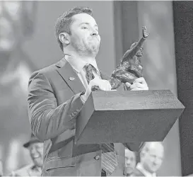  ?? Todd J. Van Emst / Heisman Trophy Trust via Associated Press ?? Oklahoma quarterbac­k Baker Mayfield shows off the 2017 Heisman Trophy on Saturday, easily winning with a whopping 1,098 more points than the runner-up.