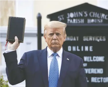  ?? PATRICK SEMANSKY / THE ASSOCIATED PRESS ?? Then-u.s. president Donald Trump holds up a Bible near the White House on June 1, 2020. Trump reported earning
$300,000 off sales of an edition of the Bible that he and country singer Lee Greenwood endorsed.