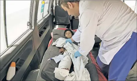  ?? Rahmat Gul Associated Press ?? A MEDIC cares for an injured boy in an ambulance on the Ghazni-Kabul highway in Maidan Shahr, southwest of the Afghan capital.