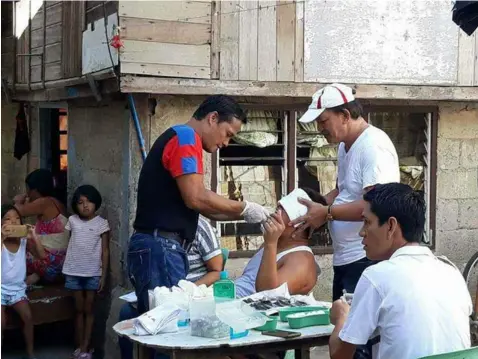  ??  ?? DENTISTA NG BAYAN
Apalit Councilor Jay Garcia Torres extracts the tooth of his patient during a dental mission. -
Chris Navarro