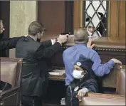  ?? J. Scott Applewhite Associated Press ?? POLICE aim their guns at protesters trying to break into the House chamber at the U.S. Capitol on Jan. 6.