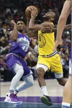  ??  ?? Golden State Warriors guard Alec Burks drives to the basket as Utah Jazz guard Donovan Mitchell defends in the first half on Friday in Salt Lake City.