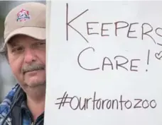  ?? RICK MADONIK/TORONTO STAR FILE PHOTO ?? Zoo mechanic Chris Theodoridi­s holds a sign the day workers walked out.