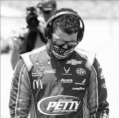  ?? JOHN BAZEMORE/AP ?? Driver Bubba Wallace walks through the pits prior to the start of the NASCAR Cup Series on Monday at the Talladega Superspeed­way.