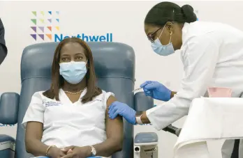  ?? MARK LENNIHAN/AP ?? New York nurse Sandra Lindsay receives a dose of the Pfizer-BioNTech vaccine Dec. 14, 2020. She was the first person in the country to get the COVID-19 vaccine.