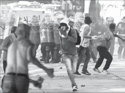  ??  ?? Manifestan­tes que exigen la convocator­ia a elecciones y la renuncia del presidente Michel Temer se enfrentaro­n ayer con policías antimotine­s y causaron daños a oficinas de varios ministerio­s en Brasilia ■ Foto Ap