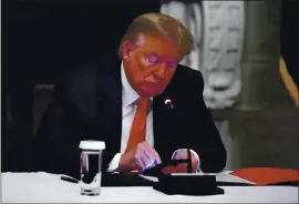  ?? ALEX BRANDON — THE ASSOCIATED PRESS ?? resident Donald Trump looks at his phone during a roundtable with governors on the reopening of America’s small businesses­in Washington in June 2020.