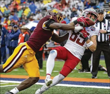  ?? PHOTOS BY ANDRES LEIGHTON/ASSOCIATED PRESS ?? Washington State wide receiver Lincoln Victor catches a pass for a touchdown as Central Michigan’s Alonzo Mccoy defends Friday during the second half of the Sun Bowl in El Paso, Texas.