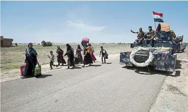  ?? — AFP ?? Heading for safety: Iraqi families travelling on foot near al-Sejar village, Anbar province, after fleeing the city of Fallujah.