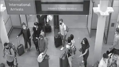  ??  ?? LONDON
Passengers wearing protective face masks arrive from Paris at Eurostar terminal at St Pancras station.
-REUTERS