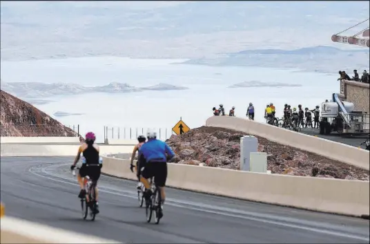  ?? K.M. Cannon Las Vegas Review-Journal @KMCannonPh­oto ?? Cyclists check out the overlook above Lake Mead while riding on Interstate 11 Saturday.