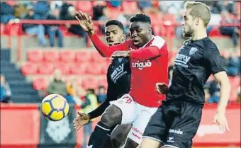  ?? LFP ?? El grana Dongou disputa un balón con dos jugadores del Huesca en el Nou Estadi