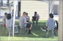  ??  ?? The other half of Naomi Calvino’s sixth-grade class works outdoors under the tents.