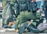  ??  ?? PINNED: Hong Kong cops hold a man Sunday.