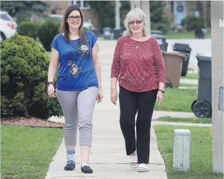  ?? DAN JANISSE ?? Theresa Shepley and her mother Marilyn Martin take a walk Thursday in Tecumseh. Together, they have lost a combined 188 pounds.