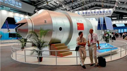  ??  ?? Visitors sit beside a model of China’s Tiangong-1 space station at the 8th China Internatio­nal Aviation and Aerospace Exhibition in Zhuhai in southern China’s Guangdong Province.