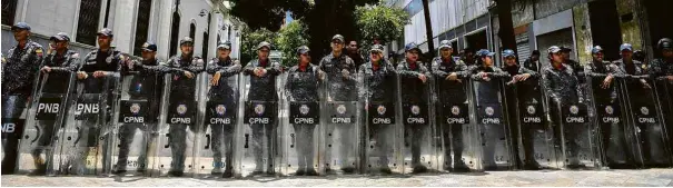  ?? Ronaldo Schemidt/ AFP ?? Agentes da polícia bolivarian­a bloqueiam um dos acessos ao prédio da opositora Assembleia Nacional, em Caracas