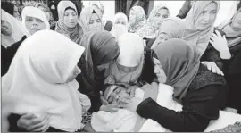  ?? Abed al Hashlamoun European Pressphoto Agency ?? RELATIVES GRIEVE at the funeral for Mohammad Jabari, 17, in the West Bank city of Hebron. The teen was killed, police said, after he stabbed an Israeli officer.