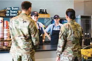  ?? MICHAEL CIAGLO/THE NEW YORK TIMES ?? Sandwich shop workers Juniper Cristan, second from left, and Melody Orman talk to army recruiters July 6 in Colorado Springs, Colorado. All branches of the armed forces are facing many factors limiting recruiting.