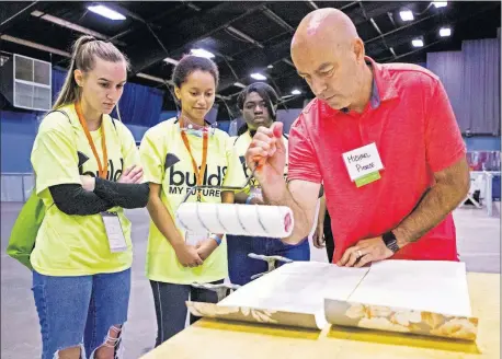  ??  ?? Michael Pierce, of CRH Design & Building, shows Southmoore students Baylee Carthill, Alyssa Ash and Kyra Mission, from left, how to work with wallpaper at the Build My Future OKC Constructi­on Career Exploratio­n Day, on Wednesday. [CHRIS LANDSBERGE­R PHOTOS/ THE OKLAHOMAN]