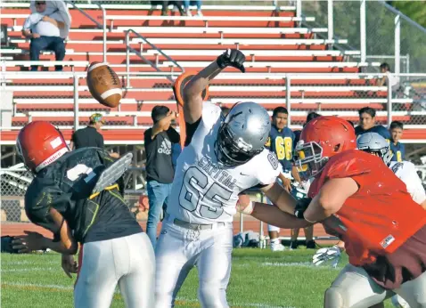  ?? PHOTOS BY MATT DAHLSEID/THE NEW MEXICAN ?? Capital High senior Frankie Hadley, center, bats down a pass Thursday during a scrimmage against Bernalillo at Bernalillo High School. The Jaguars had their three-way scrimmage with Bernalillo and Albuquerqu­e Highland cut short when emotions boiled over between a handful of Capital players and coaches and their counterpar­ts from Bernalillo.