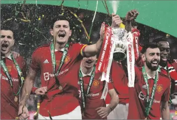  ?? ALASTAIR GRANT/AP ?? MANCHESTER UNITED’S BRUNO FERNANDES, CENTRE RIGHT, AND HARRY MAGUIRE, SECOND FROM LEFT, hold the trophy during celebratio­n as they won the English League Cup final between Manchester United and Newcastle United at Wembley Stadium in London on Sunday.