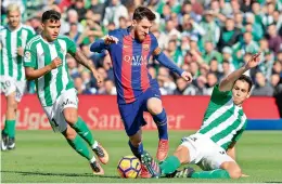  ?? —AP ?? Barcelona’s Lionel Messi rides the challenges of Real Betis defenders during their La Liga clash on Sunday.