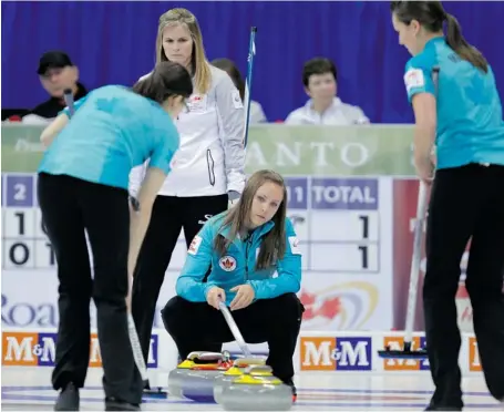  ?? BORIS MINKEVICH/WINNIPEG FREE PRESS ?? A heavy rock in the 10th end from Rachel Homan, centre, gave Jennifer Jones, background, a 7-6 win Wednesday at the Roar of the Rings tournament.