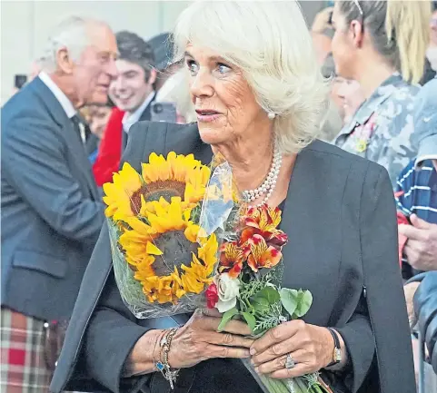  ?? Picture Andrew Milligan ?? The Queen Consort is given a bouquet of sunflowers as she leaves the Scottish Parliament with King Charles on Monday