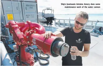  ??  ?? Ship's boatswain Antoine Amory does some maintenanc­e work of the water cannon