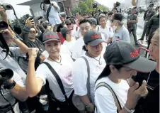  ?? SAKCHAI LALIT/THE ASSOCIATED PRESS ?? Thai activists gather in front of a police station in Bangkok, Thailand, on Thursday. Nearly three dozen activists turned themselves in to police after being summoned.