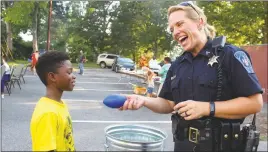 ?? STAFF PHOTO BY GRETCHEN PHILLIPS ?? Cpl. Angela Delozier talks with Julian Collins, 9, during a National Night Out celebratio­n in Lexington Park earlier this month about the first thing a person should do when entering a car. Delozier speaks with students on a regular basis about safe...
