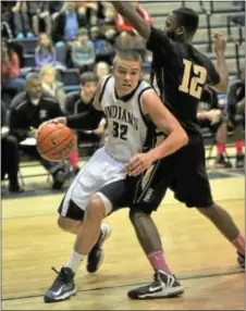  ?? Photo by John Gleeson ?? Council Rock North senior Kyle McCloskey (#32) is guarded closely by Truman senior Merdic Green (#12) in Tigers win Jan. 25 at North.