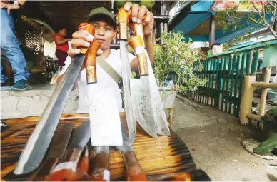  ?? ?? ANNIVERSAR­Y EXHIBIT – A bladesmith presents hand-crafted local knives for sale in an exhibit during the 42nd founding anniversar­y of the municipali­ty of Aleosan, North Cotabato on Thursday, April 4, 2024. (Keith Bacongco)