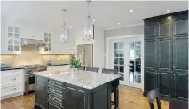  ??  ?? TOP: The main-floor open concept kitchen features custom millwork, stone countertop­s and a beautiful backsplash.